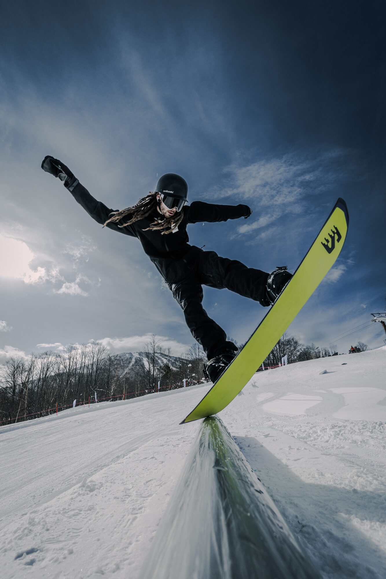 Snowboarder on rail under dark sky