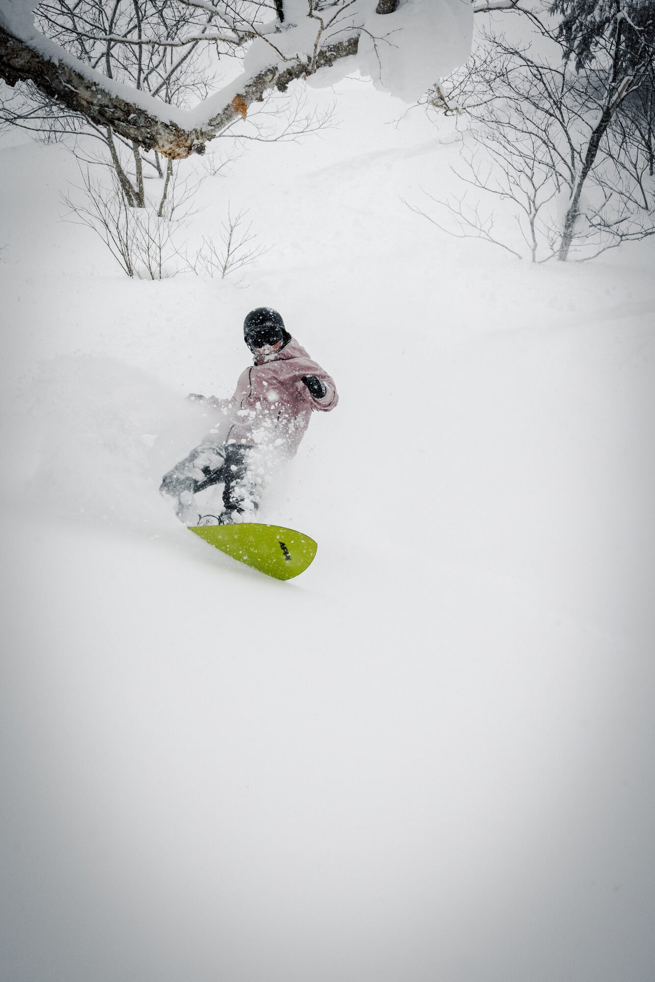 Snowboarder bursting through deep powder